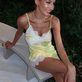 Woman in a yellow lace dress sitting on a bench outdoors